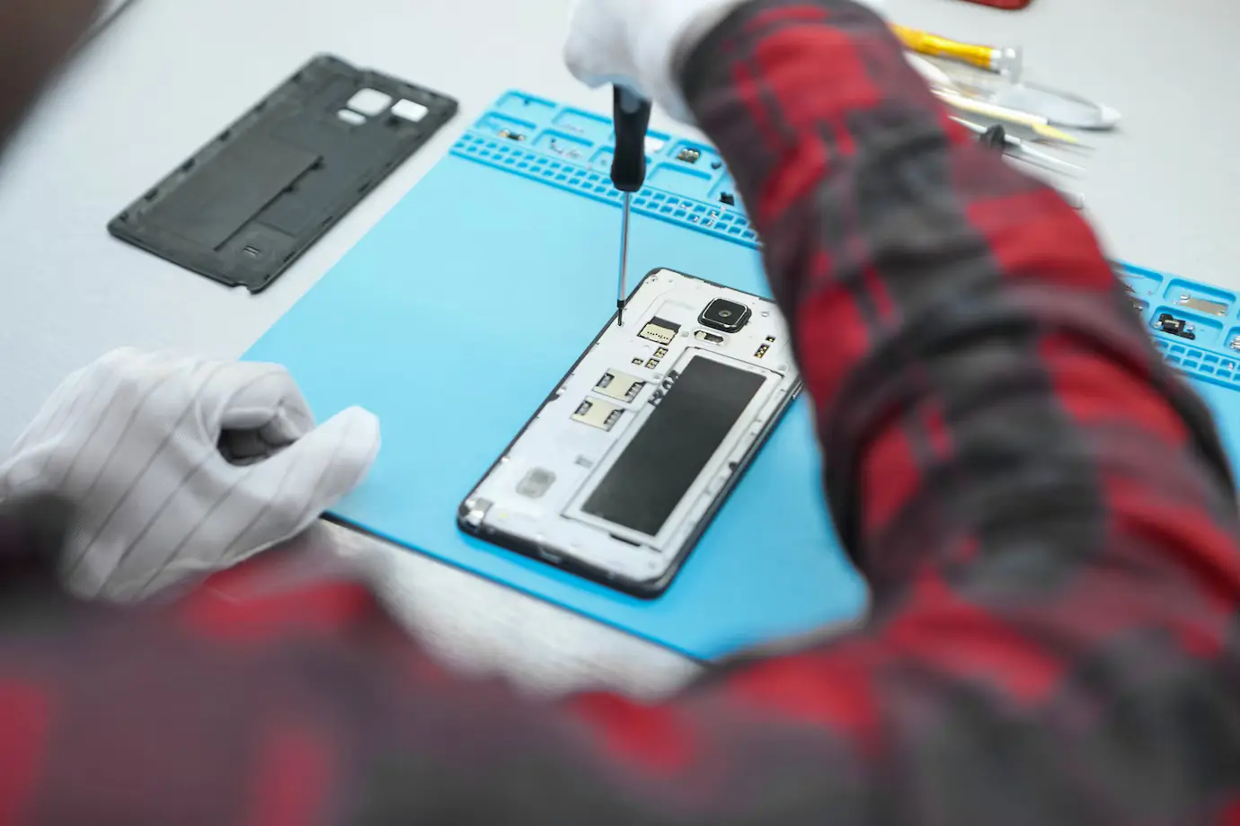 Technician practising smartphone repair at a workstation